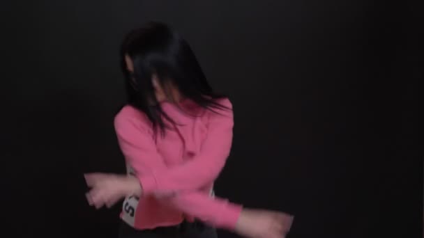 Крупним планом молода крута біла жінка танцює і стрибає з хвилюванням перед камерою — стокове відео
