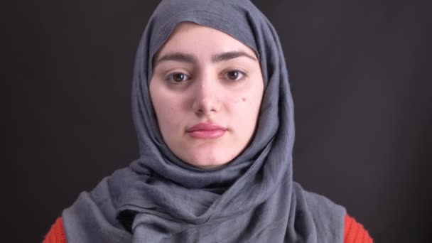 Portret van vrouwelijke handen doen make-up met zwart potlood voor jonge moslimvrouw in hijab op zwarte achtergrond. — Stockvideo