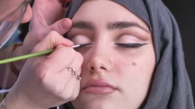 Yakın çekim gözlük siyah oku hijab siyah arka plan üzerine çekici Müslüman kadın için ince düz fırça kullanarak çizim kadın portresi.