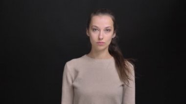 Cidden içine kamera siyah arka plan üzerine izlerken at kuyruğu ile genç esmer beyaz kız portresi.