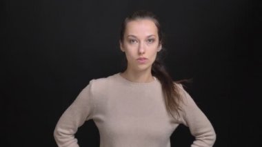At kuyruğu siyah arka plan üzerine kamera içine ciddi ve threateningly izlerken genç esmer beyaz kız portresi.