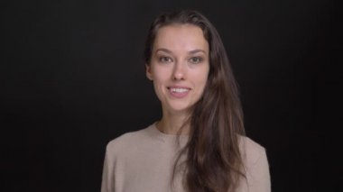 Esmer uzun saçlı beyaz kız portresi birini karşılayan ve siyah arka plan üzerine olumlu eğlence fotoğraf makinesi içine gösterir.
