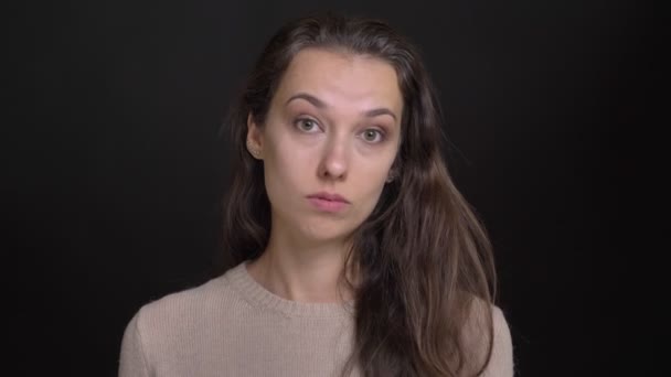 Portrét detail brunetka dlouhé vlasy-kavkazský dívky, souhlasně přikyvuje do kamery na černém pozadí. — Stock video