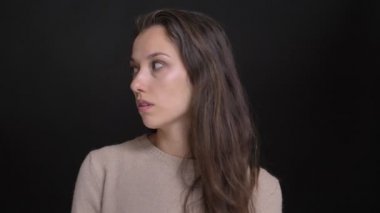 Esmer uzun saçlı beyaz kız şaşkınlık içine kamera siyah arka plan üzerine diye yakın çekim portresi.