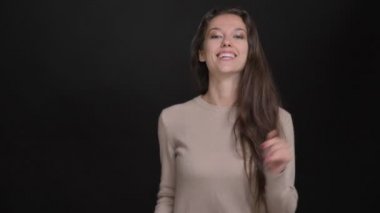 Esmer uzun saçlı beyaz kız gülümseyerek dans müzik için siyah arka plan üzerine yakın çekim portre.