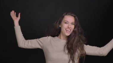Garip bir şekilde siyah arka planda müzik dans esmer uzun saçlı beyaz kız portresi.