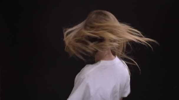 즐거운 젊은 백인 기꺼이 춤을 카메라에 검은 배경에 격자 무늬 셔츠에 긴 머리 여자의 초상화. — 비디오
