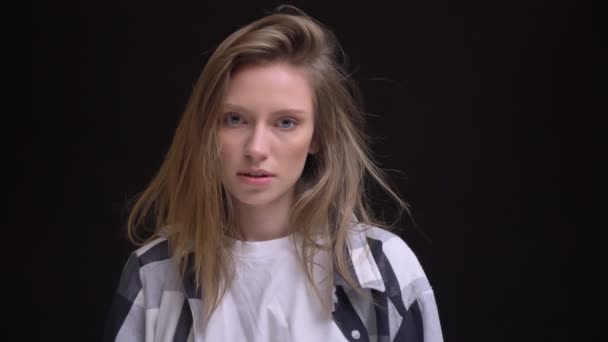 Retrato de jovem caucasiano de cabelos compridos menina na camisa xadrez moda posando para a câmera no fundo preto . — Vídeo de Stock