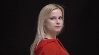 Kırmızı kapüşonlu genç beyaz saçlı beyaz kız portresi için fotoğraf makinesinin ve sakin bir şekilde içine kamera siyah arka plan üzerine saatler.