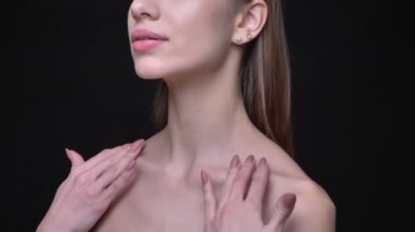 Yakın çekim portre profil genç beyaz kızın çıplak makyaj yumuşak siyah arka plan üzerine onun köprücük kemiği dokunmadan ile.