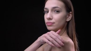 Profil sahibi genç ve ince beyaz kız çıplak makyaj yumuşak onun omuz ve köprücük kemiği siyah arka plan üzerine dokunmadan ile portre.