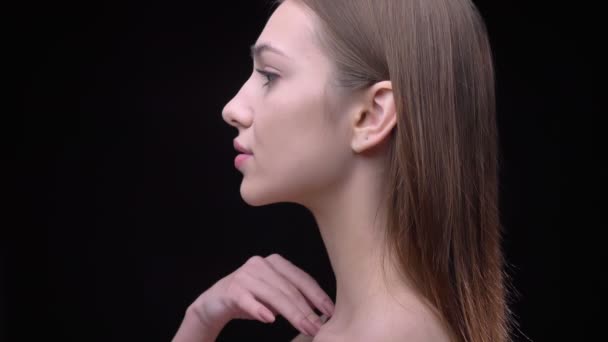 Portrét v profilu mladých a tenký kavkazský dívky s nude make-up jemně dotýkat krku na černém pozadí. — Stock video