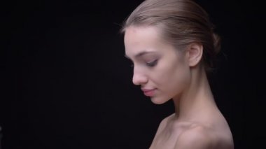 Portre profil yavaş yavaş hareket ve ciddi kamera siyah arka plan üzerine içine izlerken çıplak makyaj ile ince beyaz kızın.