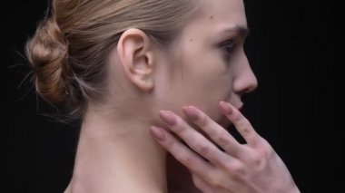 Usulca ona boyun ve yüz dokunmaktan ve siyah arka plan üzerine kamera içine izlerken ince beyaz kız portresi etrafında çember.