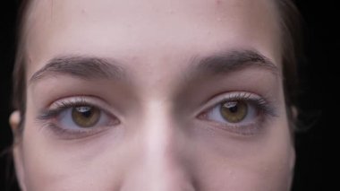 Genç ve ince beyaz kız çıplak makyaj sakince kamera siyah arka plan üzerine içine izlerken ile yakın çekim göz-portre.