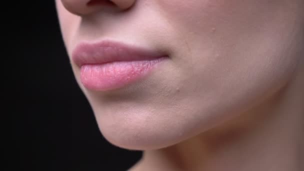 Close-up lábios-retrato de jovem e magro menina caucasiana com nude make-up em movimento sobre fundo preto . — Vídeo de Stock