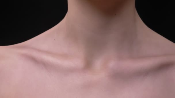 Close-up portrait of skinny female collarbone moving on black background. — Stock Video