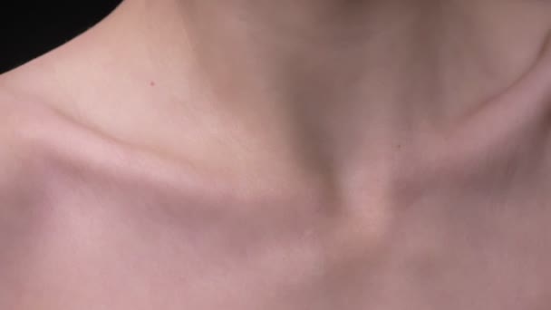 Close-up retrato de menina branca magra em movimento e mostrando sua clavícula e ombros em fundo preto . — Vídeo de Stock