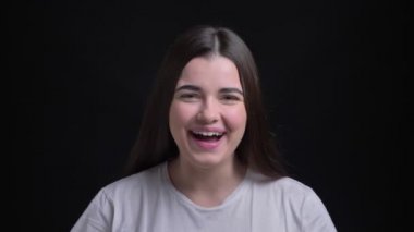 Genç kilolu esmer beyaz kız kamera içine aşırı mutluluk siyah arka plan üzerinde gösterilen portresi.
