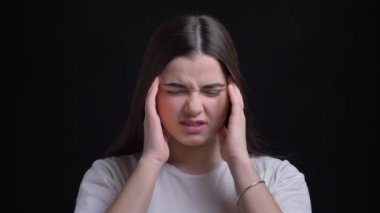 Portre genç kilolu esmer beyaz kızın acı baş ağrısı ve yapma masaj siyah arka plan üzerine gelen.