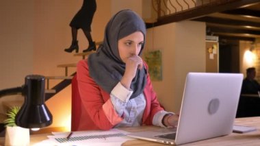Diyagramlar ve grafikler laptop kapalı işyeri önünde Datası inceleyerek hijab işçisi genç meşgul Müslüman ofis portre portre