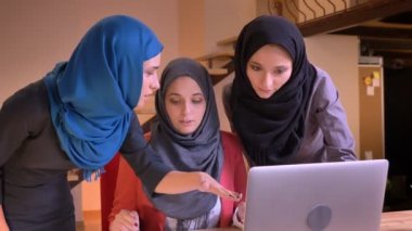 Üç genç neşeli Müslüman mecaz tablet laptop bir konuda karşılaştırma canlı sohbet hijabs içinde closeup portresi