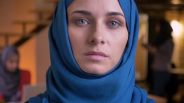 Mavi hijab doğruca kameraya duygusuz yüz ifadesi ile seyir yetişkin Müslüman işkadını closeup portresi