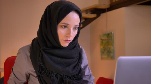 Portrait rapproché de jeunes femmes arabes attrayantes tapant sur l'ordinateur portable, puis regardant la caméra et souriant joyeusement — Video