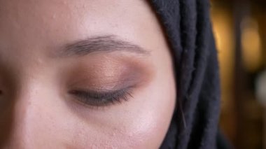 Doğruca kameraya tarafsız yüz ifadesi ile seyir siyah Tesettür genç güzel Müslüman kadın portre yarı-yüz portresi