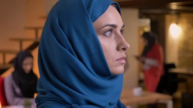 Taraftan dönüm ve doğruca kameraya bakarak mavi hijab genç güzel Müslüman kadın portresi portre