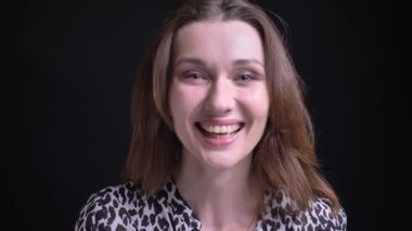 Genç mutlu beyaz esmer kadın gülümseyerek ve neşeyle doğruca kameraya bakarken gülüyor portre portre