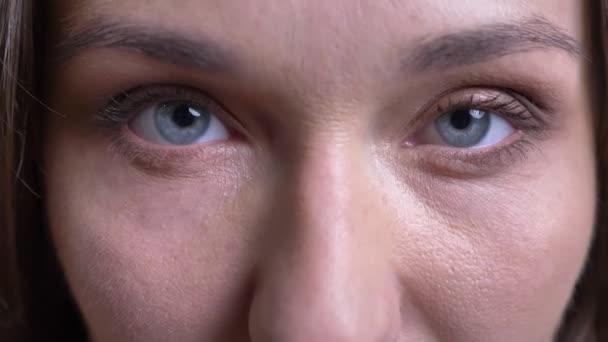 Closeup portret van volwassen Kaukasische vrouwelijke gezicht met blauwe ogen openen en direct kijken camera wordt gesloten — Stockvideo