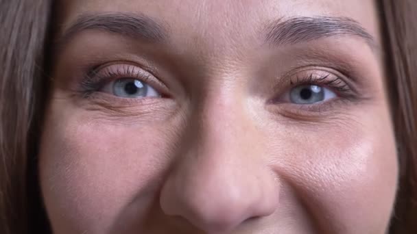 Närbild porträtt av vuxna vackra kaukasiska kvinnliga ansiktet med blå ögon tittar på kamera med leende ansiktsuttryck — Stockvideo