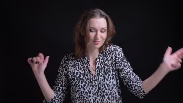 Nahaufnahme Porträt einer jungen schönen brünetten kaukasischen Frau, die lässig tanzt und Spaß vor der Kamera hat — Stockvideo