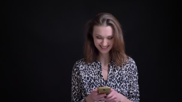 Vértes portré fiatal gyönyörű kaukázusi barna női textil a telefon mosolyogva, majd keres, a kamera, és nevetve — Stock videók