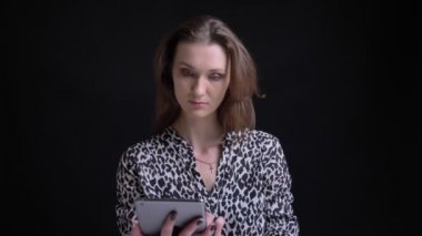 Kamera önünde genç çarpıcı beyaz esmer tableti kullanarak ve sosyal medyaya tepki kadın portresi closeup mesajları