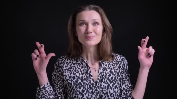 Крупный план портрета взрослой белой женщины, беспокоящейся и скрещивающей пальцы, глядя прямо в камеру — стоковое видео