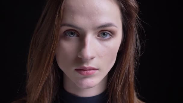 Close-up ritratto di giovane e sottile bruna caucasico ragazza guardando con calma in macchina fotografica su sfondo nero . — Video Stock
