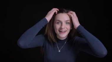 Yakın çekim fotoğraf makinesi içine pozitif eğlence siyah arka plan üzerinde gösterilen genç ve ince esmer beyaz kız portresi.