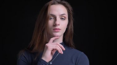 Yakın çekim zarif şekilde içine kamera siyah arka plan üzerine poz genç ve ince esmer beyaz kız portresi.