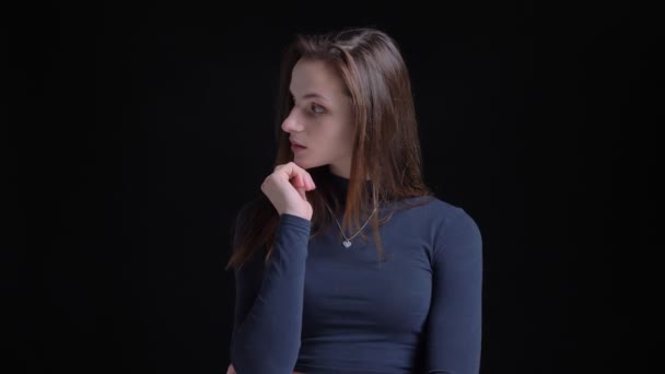 Portret van jonge en slanke brunette Kaukasische meisje fashionably poseren in camera op zwarte achtergrond. — Stockvideo