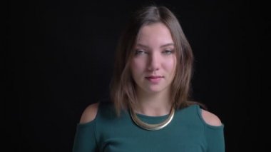 Kameraya gülümseyen ve saçlarını flirtingly siyah arka plan üzerine sabitleme genç esmer beyaz kız portresi.