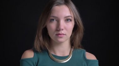 Gülümseyerek başını sallayarak ve siyah arka plan üzerine kamera içine izlerken genç esmer beyaz kız portresi yakın çekim.