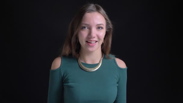 Retrato de la joven morena caucásica sacudiendo su pelo felizmente sobre fondo negro . — Vídeos de Stock