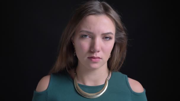 Detail portrét mladé dlouhosrsté bruneta kavkazský dívky trpí bolest hlavy na černém pozadí. — Stock video