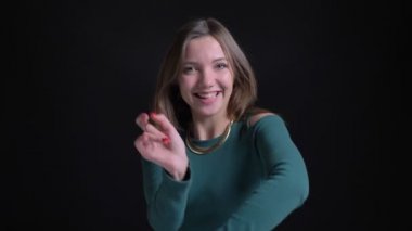 Sevinçle dans ve siyah arka plan üzerine kamera içine izlerken genç esmer beyaz kız portresi yakın çekim.