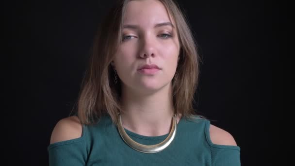 Close-up portret van jonge brunette Kaukasische meisje haar hoofd draaien negatief aan het oneens zijn over zwarte achtergrond. — Stockvideo