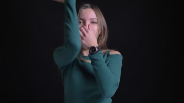 Nahaufnahme Porträt eines jungen brünetten kaukasischen Mädchens, das aktiv tanzt und auf schwarzem Hintergrund in die Kamera schaut. — Stockvideo
