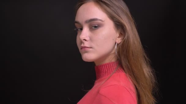 Closeup portrait of young beautiful caucasian female turning from the side and looking at camera — Stock Video