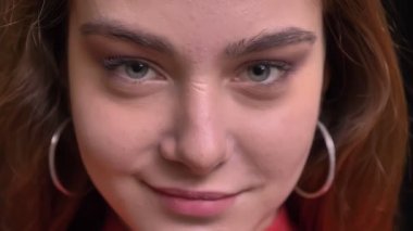 Genç güzel beyaz kadın yüzü gri gözleri doğrudan kameraya gülümseyen yüz ifadesi ile seyir closeup portresi